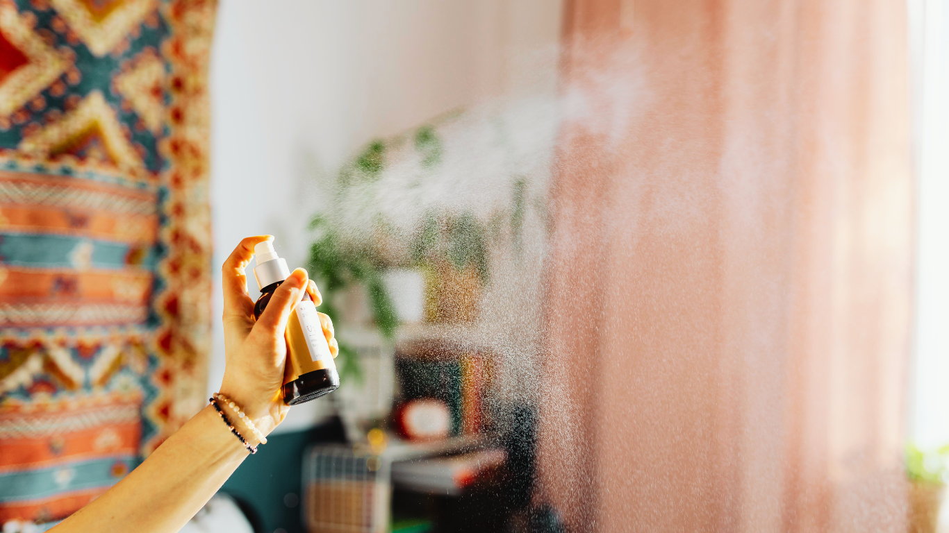 A person sprays air freshener in a cozy room, illustrating how DIY solutions often fall short for resolving serious odor problems.